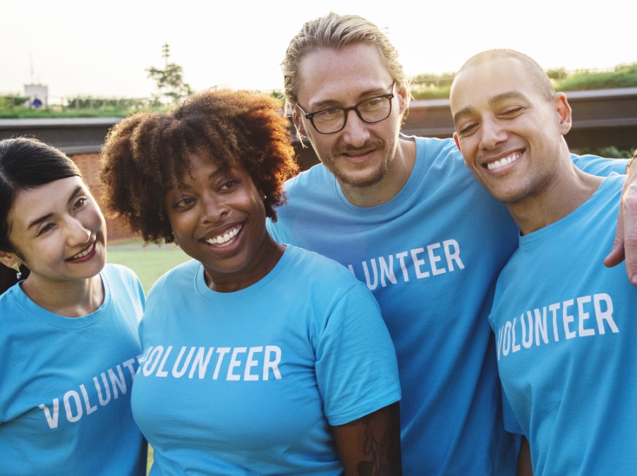 Groupe diversifié et souriant illustrant l'engagement des bénévoles facilité par Klubasso.fr France